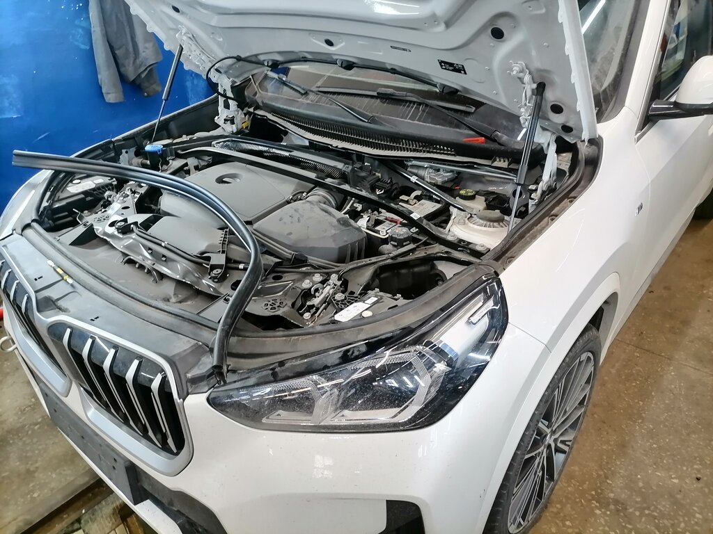 BMW с открытым капотом на диагностике в мастерской